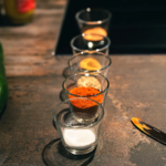 Vier Gläser mit unterschiedlich farbigen Gewürzen stehen hintereinander in einer Reihe.